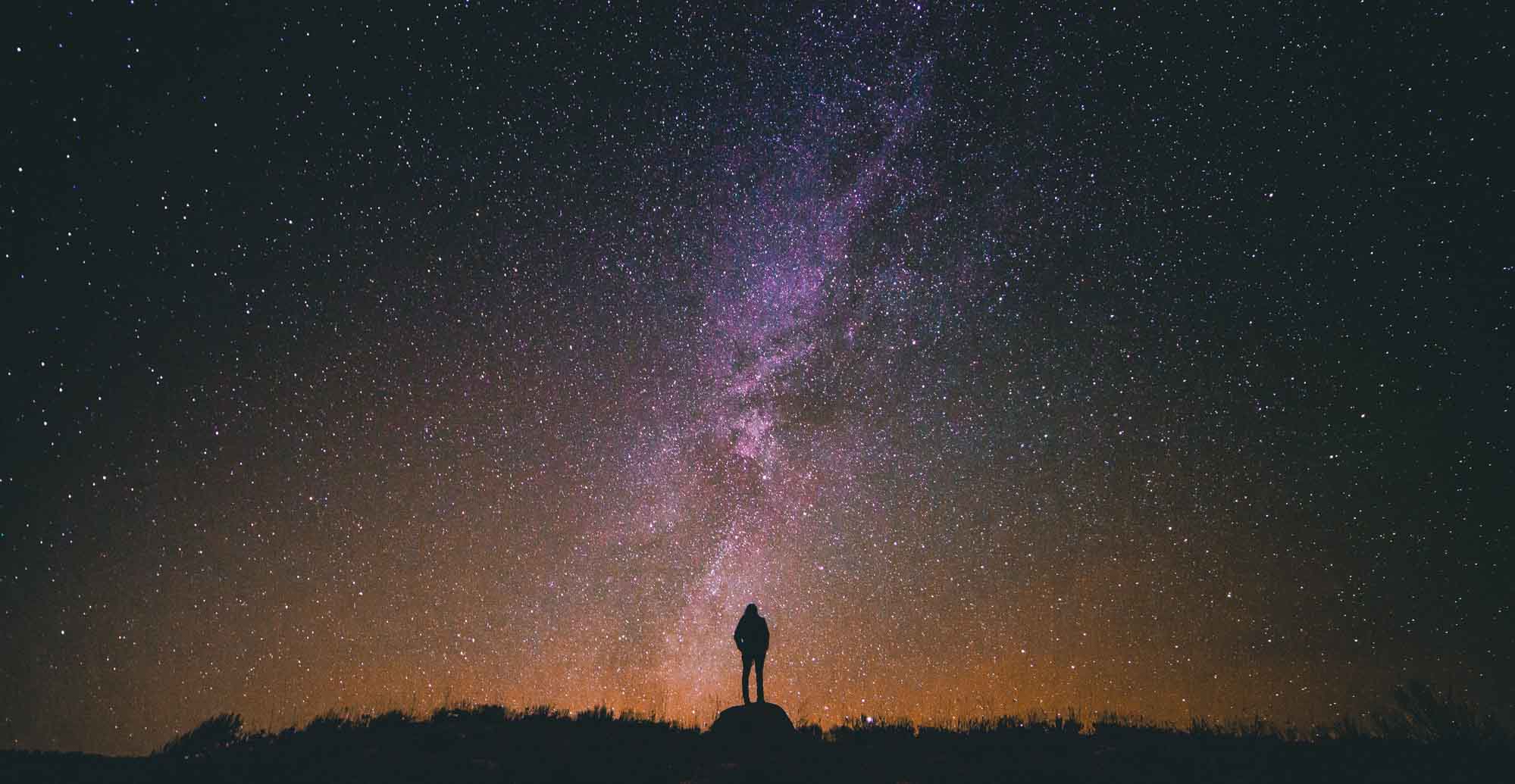 Picture of a person looking at a beautiful night sky full of stars